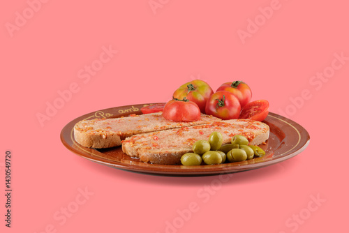 Pa amb tomAquet, the catalan tomato bread with sobrasada, served with olives and tomatoes on a brown plate