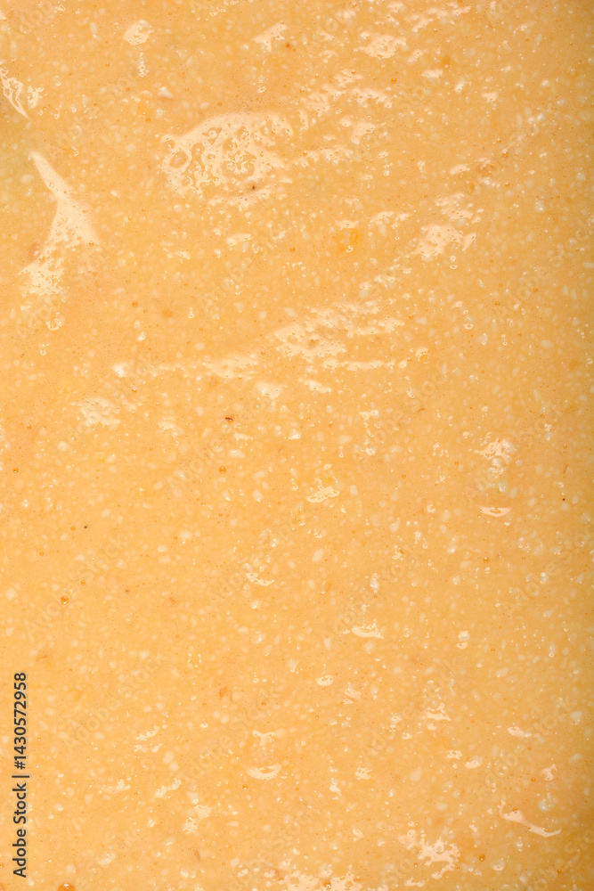 A textured, pale yellow mixture of eggs and semolina is shown in a detailed close-up, ready to be formed into dumplings for soup