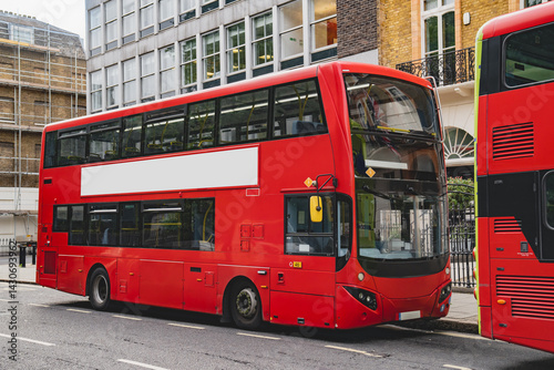 The blank ad space on the red bus contrasts with the classic charm of the calm London street.