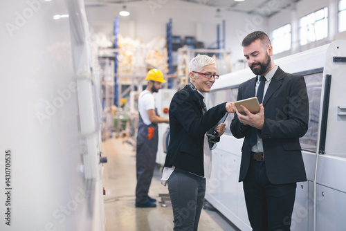 Quality inspectors team and workers at factory using machines