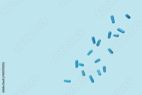 Flying blue pills on color background