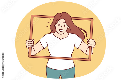 Woman peeks out of picture frame wanting to take creative shot for photo album. Positive girl in casual clothes with smile poses for photo shoot to get portrait for blog or social networks