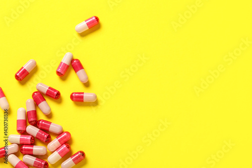 Pink hard capsules on yello...