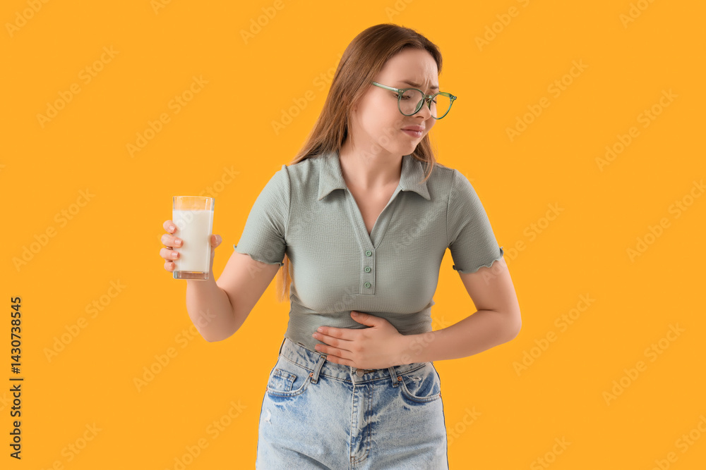 Young woman with bellyache and glass of milk on yellow background. Food Allergy Awareness Month Young woman with bellyache and glass of milk on yellow background. Food Allergy Awareness Month