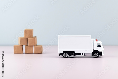Fototapeta Naklejka Na Ścianę i Meble -  White toy truck with boxes on a light background, space for text.