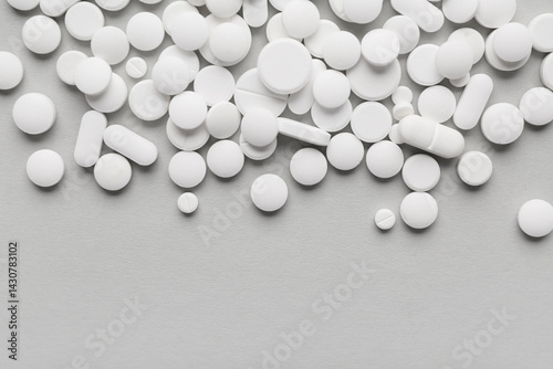 Different white pills on gr...