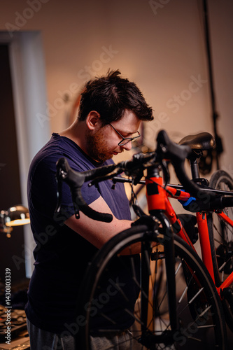 Focused Man Working on Bicycle in Home Workshop photo