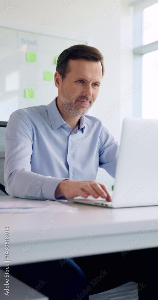 Man at office opens laptop starts working. Vertical video