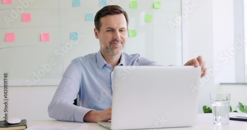 Video of businessman at office using laptop and looking out the window