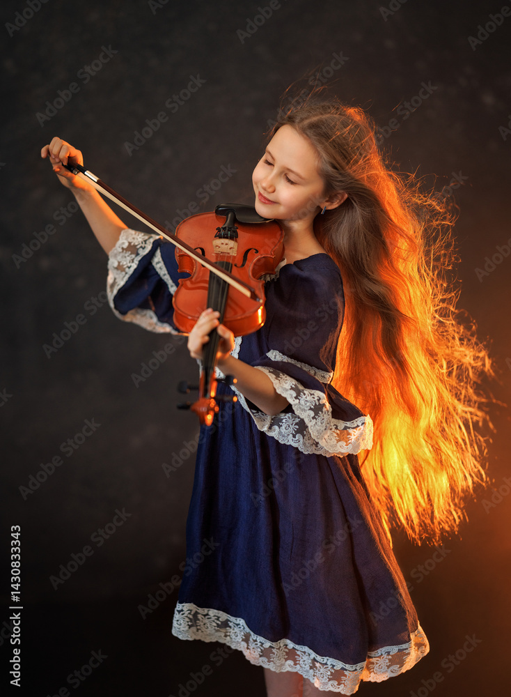 Portrait of a beautiful girl with developing long hair and a violin on a dark background in the studio. Music and art