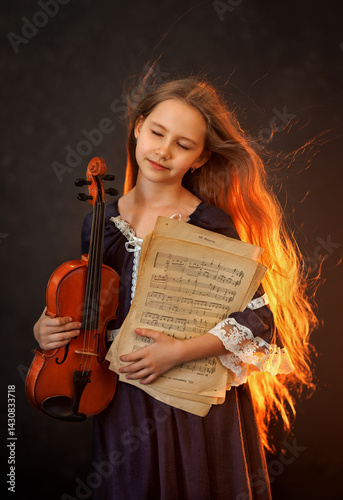 Obraz na płótnie Portrait of a beautiful girl with developing long hair and a violin on a dark background in the studio. Music and art w salonie
