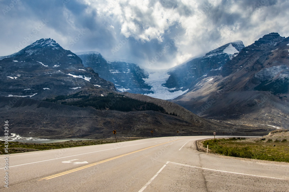 Fototapeta premium Stunning view of mountains and glacier of Columbia Icefield along winding road in national park during daytime