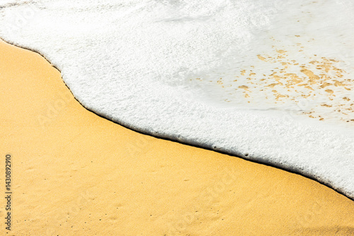 Wasserkaante mit Gischt am sandstrnd