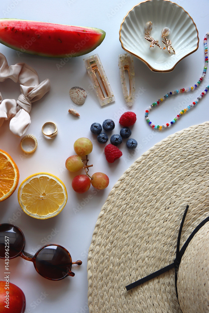 Straw hat, sunglasses, seasonal fruit, seashells and colorful accessories on white backgrounds. Cute summer essentials. Flat lay.