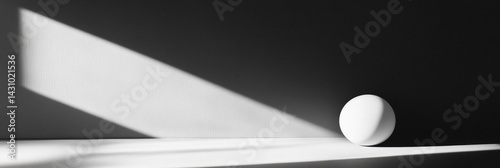 Obraz na płótnie Bright White Sphere in Deep Shadow With High Contrast Lighting Showcasing Minimalist Aesthetic in a Modern Interior Generative AI w salonie