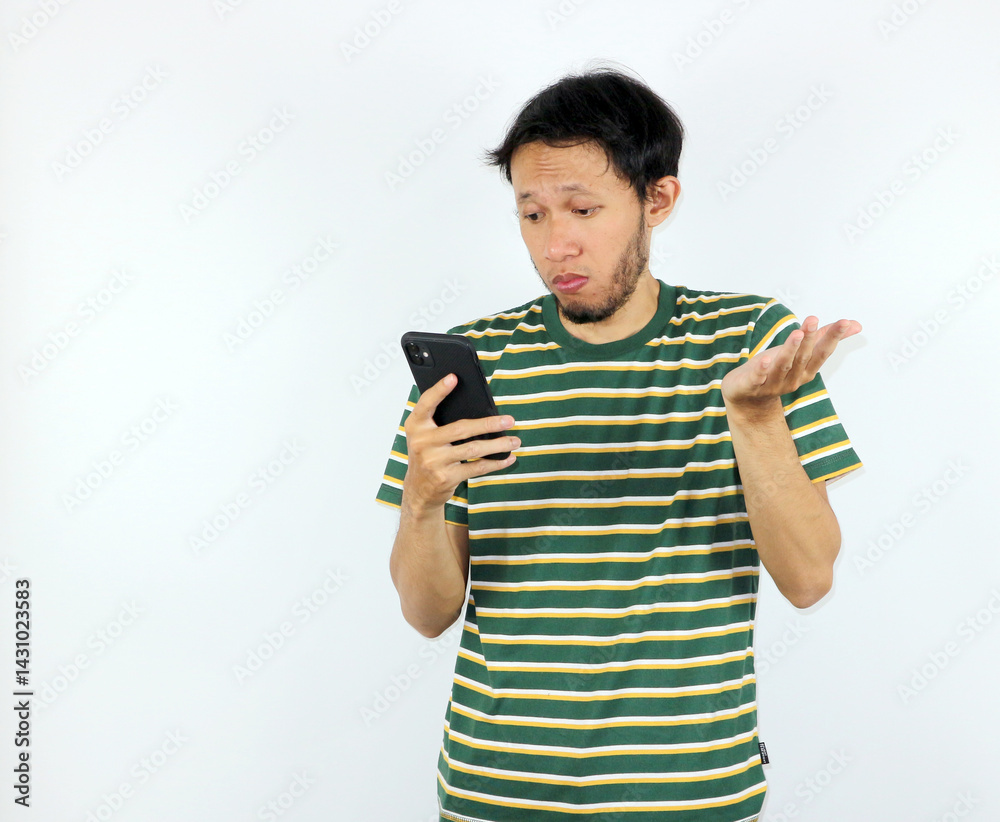 Confused Man Looking at Mobile Phone with a Questioning Gesture Confused Man Looking at Mobile Phone with a Questioning Gesture