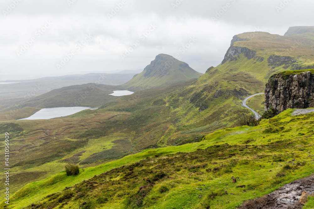 Obraz premium The Quiraing, Isle of Skye lush green landscapes, pure air, dramatic cliffs. A surreal trail through wild nature, perfect for trekking, silence, breathing untouched beauty, mystical rock formations.