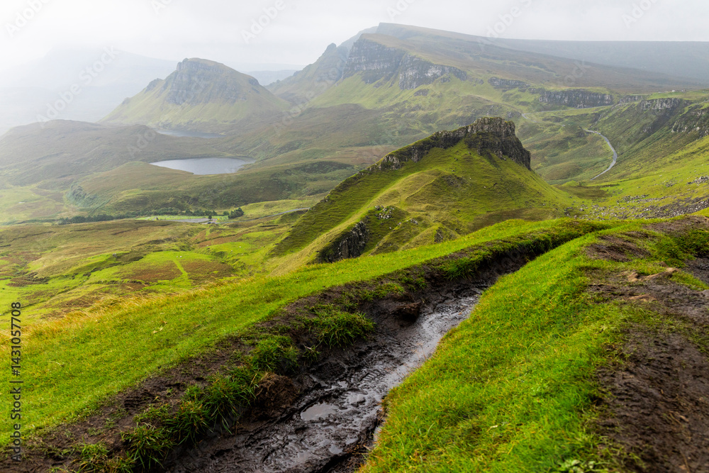 Obraz premium The Quiraing, Isle of Skye lush green landscapes, pure air, dramatic cliffs. A surreal trail through wild nature, perfect for trekking, silence, breathing untouched beauty, mystical rock formations.