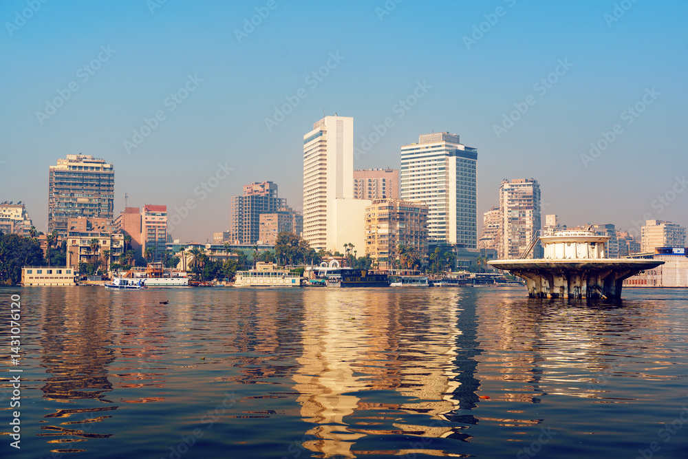 Obraz premium City skyline reflecting in the Nile River at sunset in Cairo