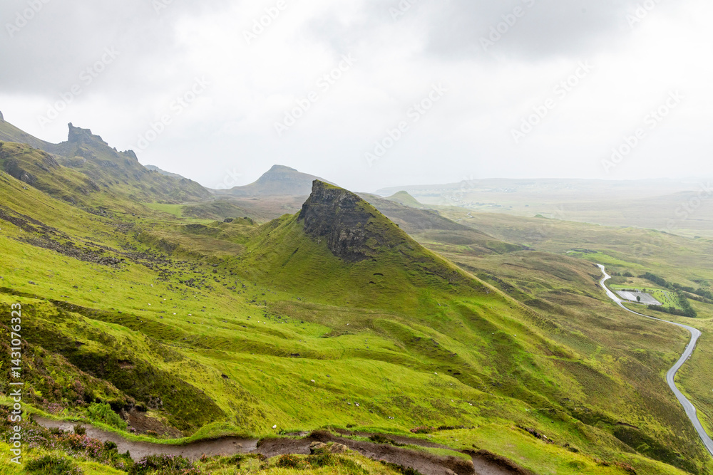 Fototapeta premium The Quiraing, Isle of Skye lush green landscapes, pure air, dramatic cliffs. A surreal trail through wild nature, perfect for trekking, silence, breathing untouched beauty, mystical rock formations.