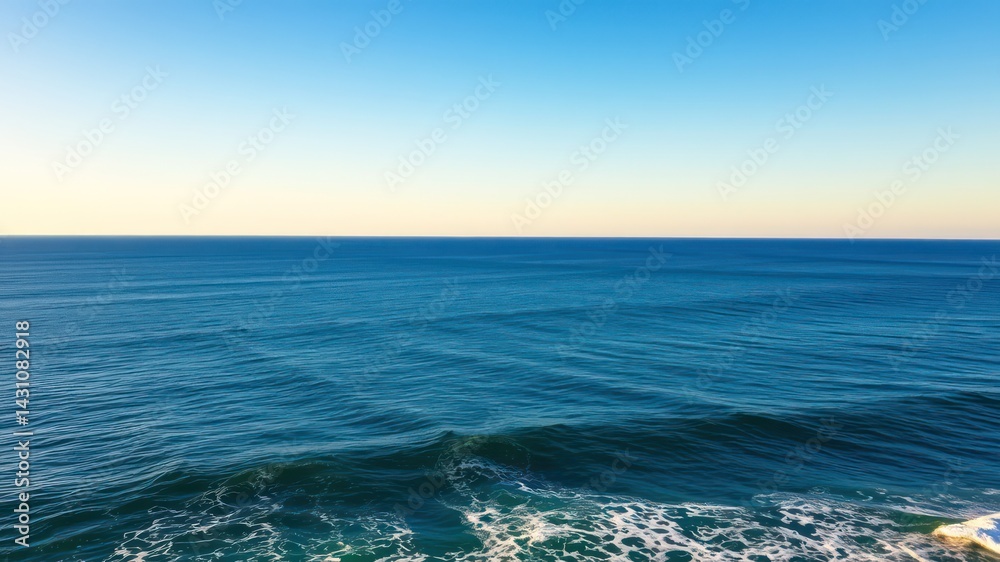 Naklejka premium Serene ocean view, vast expanse of blue water meeting a clear sky at sunset