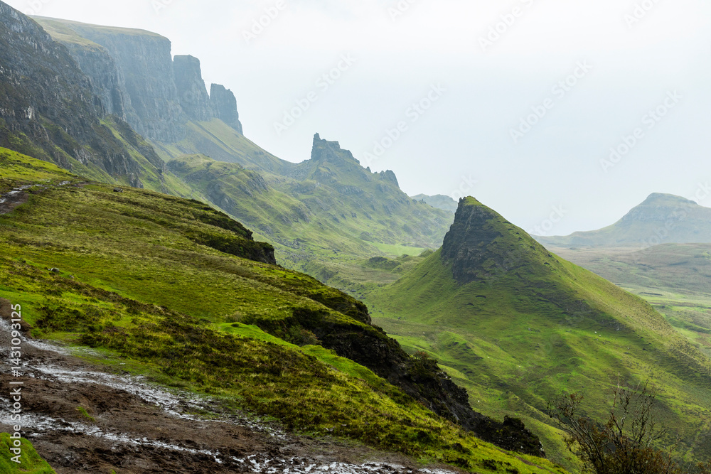Naklejka premium The Quiraing, Isle of Skye lush green landscapes, pure air, dramatic cliffs. A surreal trail through wild nature, perfect for trekking, silence, breathing untouched beauty, mystical rock formations.