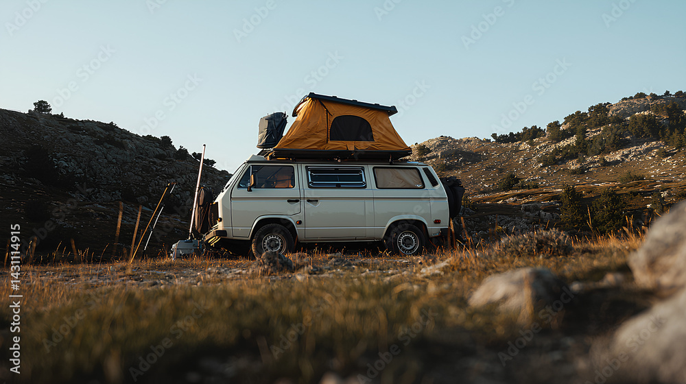 Fototapeta premium Vintage van with rooftop tent parked in mountain landscape during golden hour
