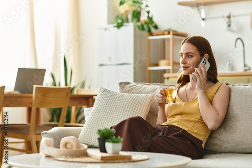 Wallpaper Mural Young woman enjoys a warm beverage while engaged in a phone conversation at home Torontodigital.ca