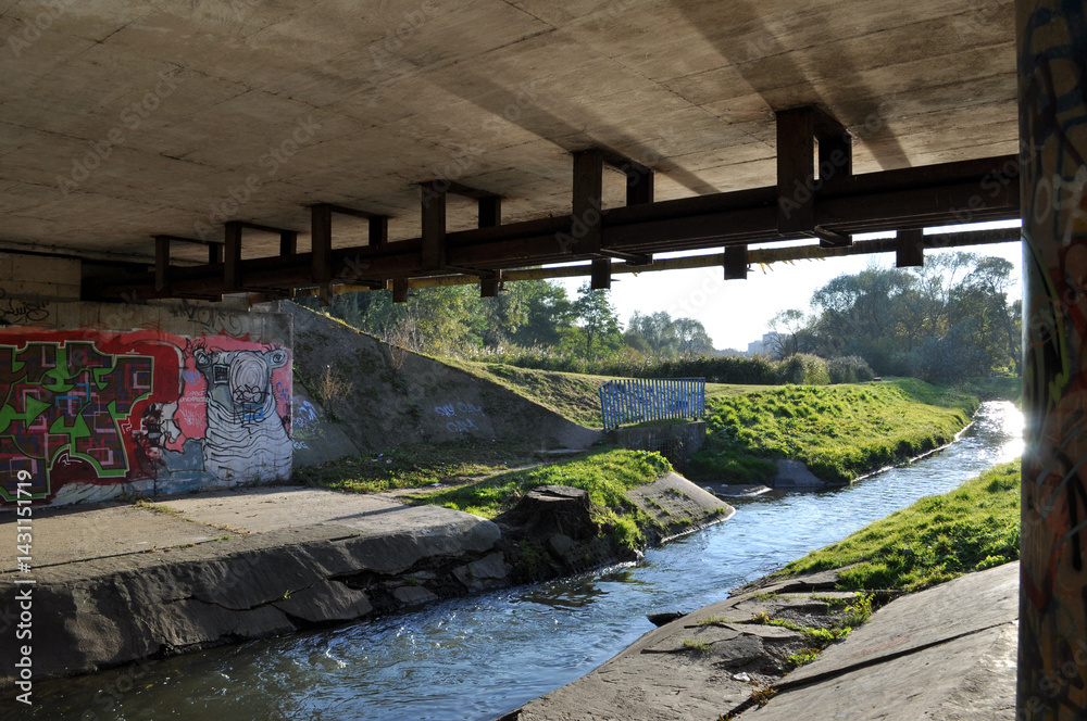 underpass under the bridge next to the stream of the river
