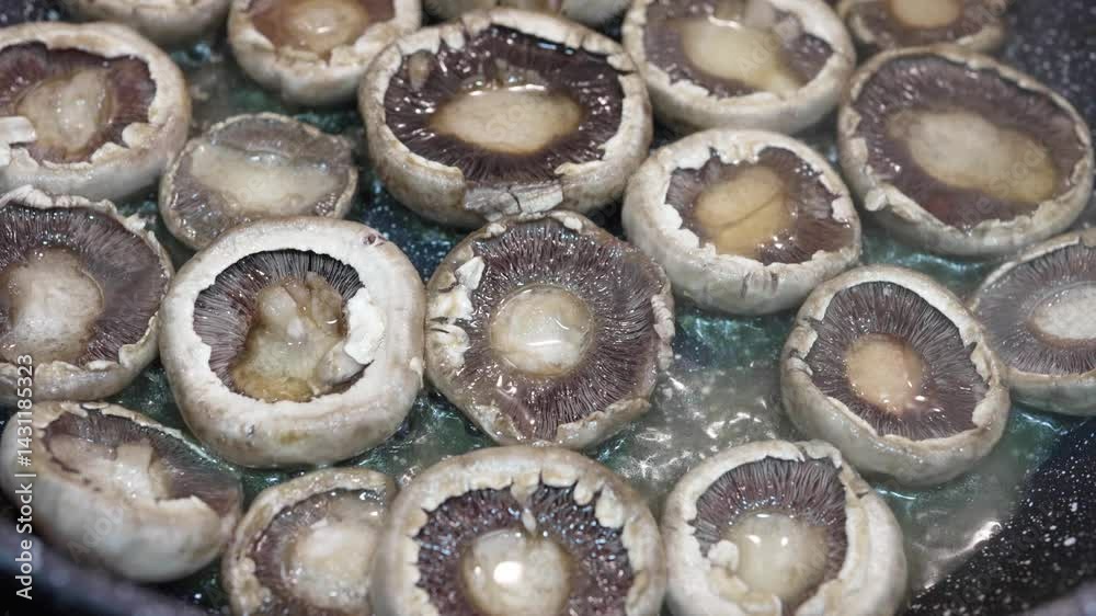 Sliced mushrooms releasing water while frying in pan Sliced mushrooms releasing water while frying in pan
