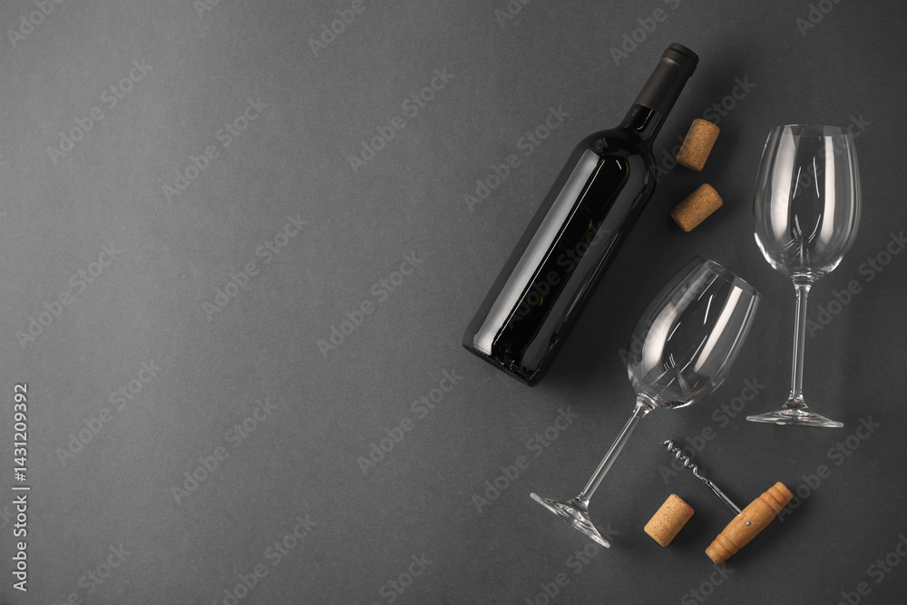 Naklejka premium Bottle of wine, corks and glasses on grey background, flat lay. Space for text