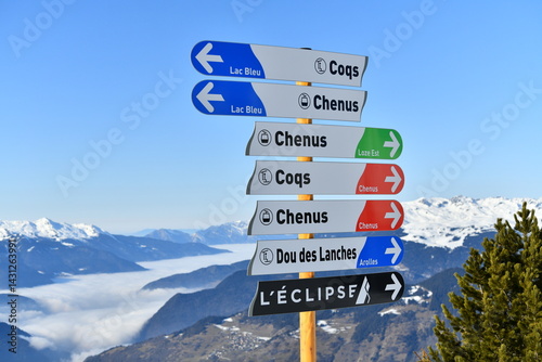 Direction signs on the slopes of Courchevel ski resort showing Chênus and Coqs slopes