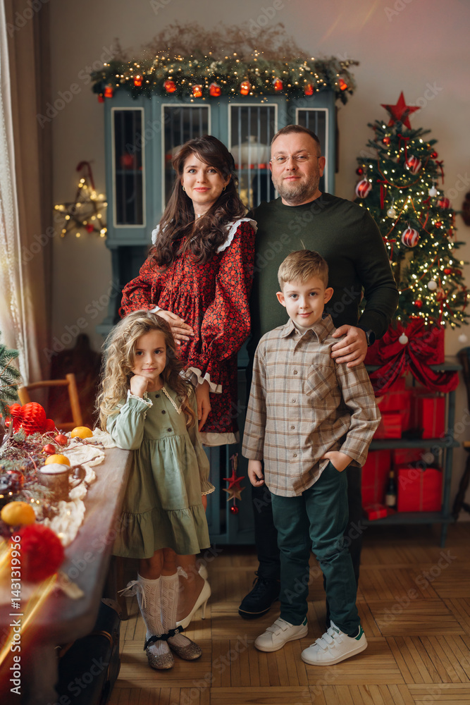 A beautiful family with a son and daughter in a room with Christmas decorations.
