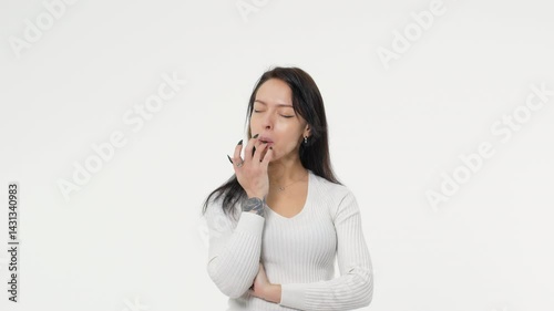 Woman, girl, chewing gum. She is unsuccessfully trying to inflate a balloon. Copy space on a white background