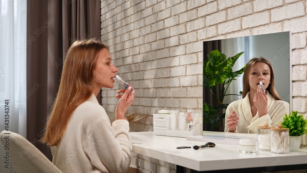 Woman Applying Lip Balm at Vanity in Modern Bathroom Woman Applying Lip Balm at Vanity in Modern Bathroom