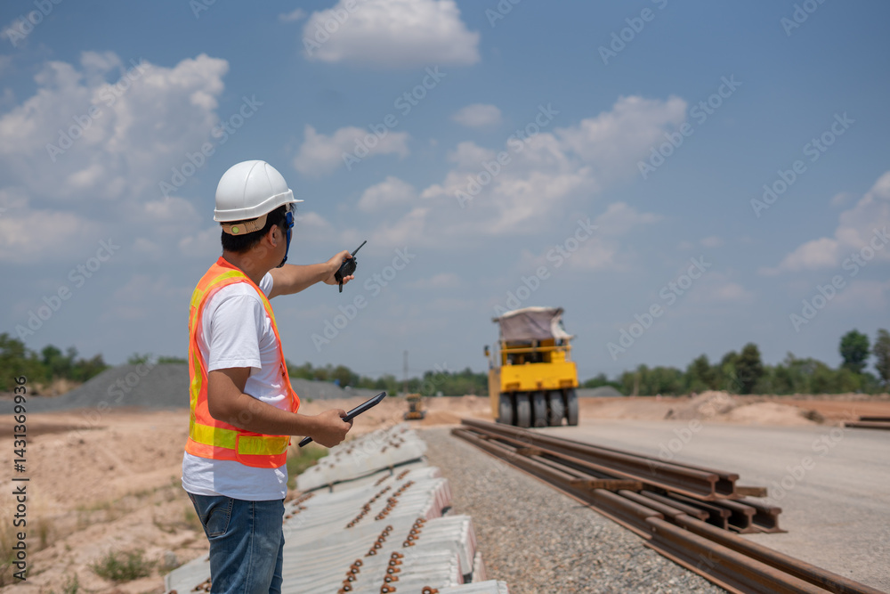 Construction Supervisor Directing Operations: An industrious construction supervisor, equipped with essential safety gear, expertly directs the team at the construction site amidst a bright blue sky.