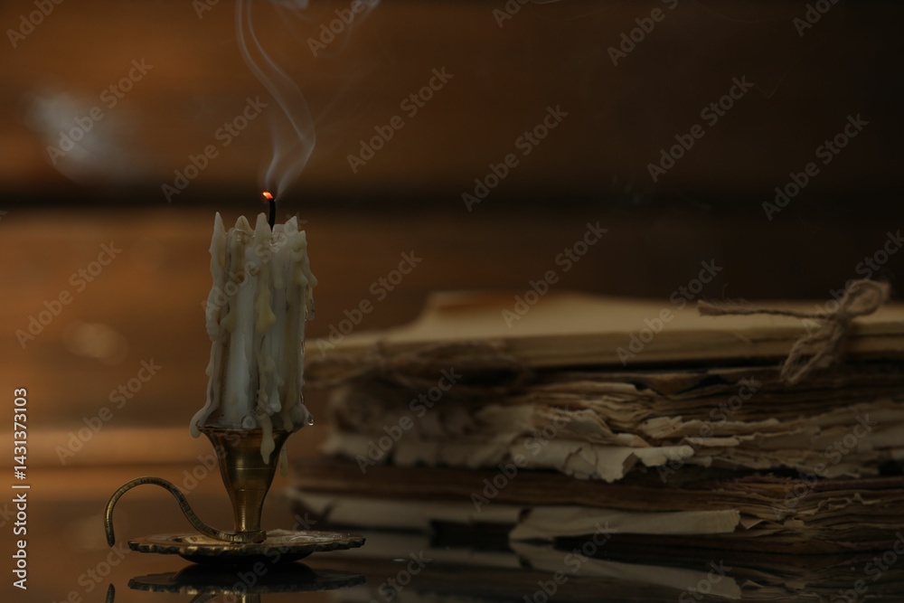 Ταπετσαρία Smoldering candle in candlestick and old books on mirror surface, closeup