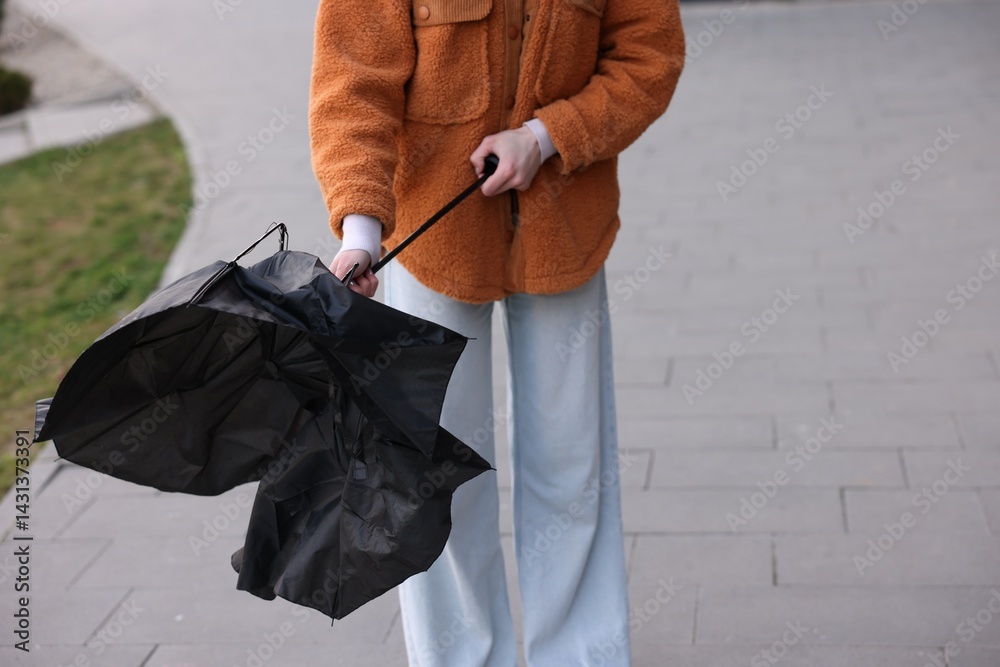 Teenage girl with broken umbrella outdoors, closeup