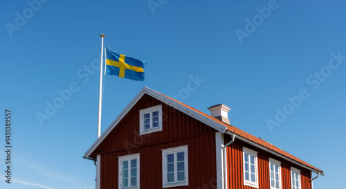 Traditional red Swedish cabin Stuga with national flag against blue sky. Close up of typical Swedish summer house architecture. National day in Sweden. 6th June. photo