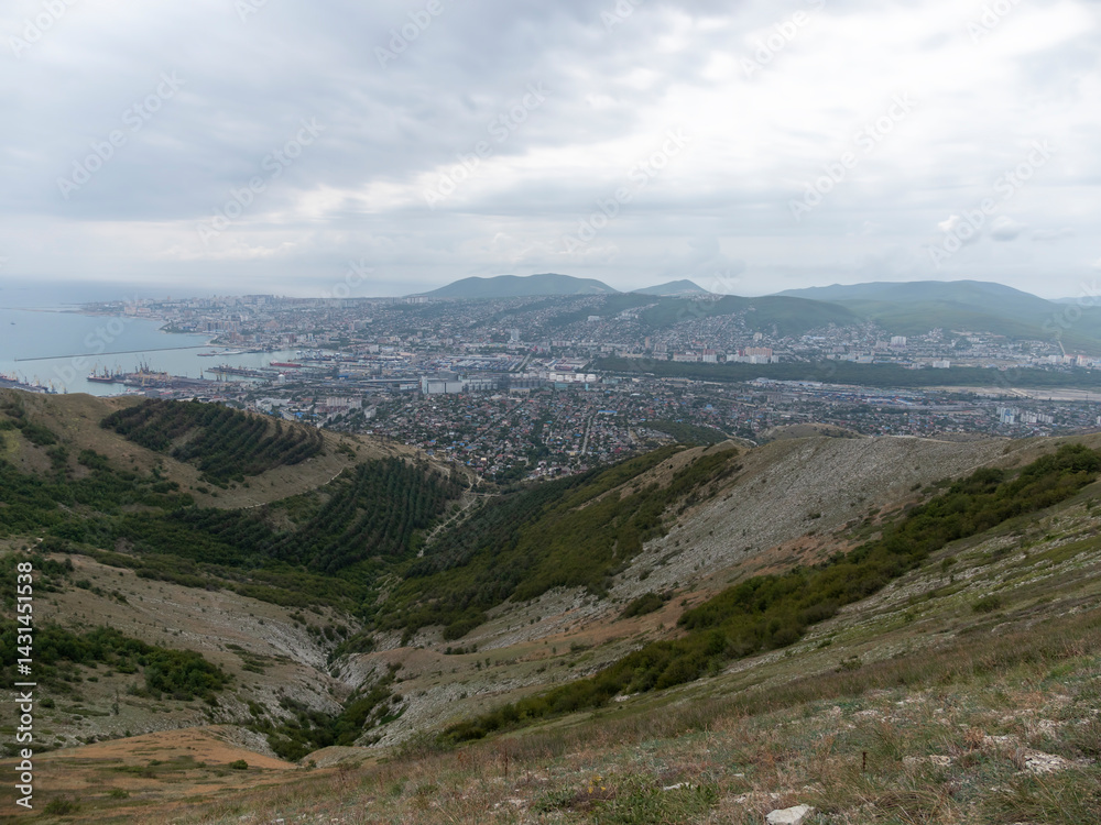 Naklejka premium Panoramic view of Novorossiysk City and Tsemess Bay at sunrise. Morning cityscape of large port at Black Sea coast in Russia