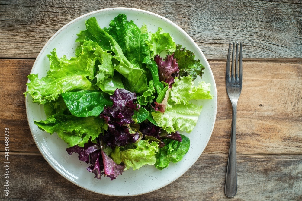 Fresh salad with fork on wooden table top view Fresh salad with fork on wooden table top view