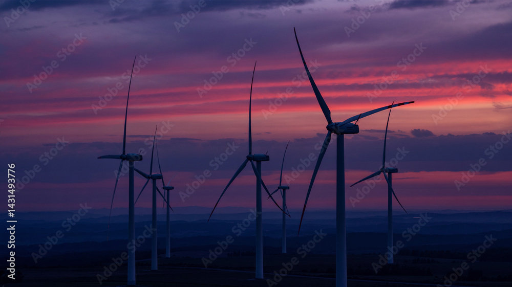 Obraz premium Wind turbines are outlined by the warm glow of the setting sun!