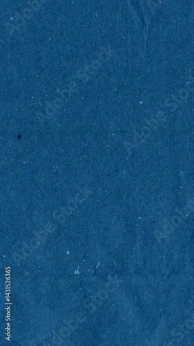 Blue kraft paper noise texture vertical stop motion video. Old page overlay effect background loop animation. Vintage paper texture with crease, stain, grain, dust particles. Empty animated backdrop