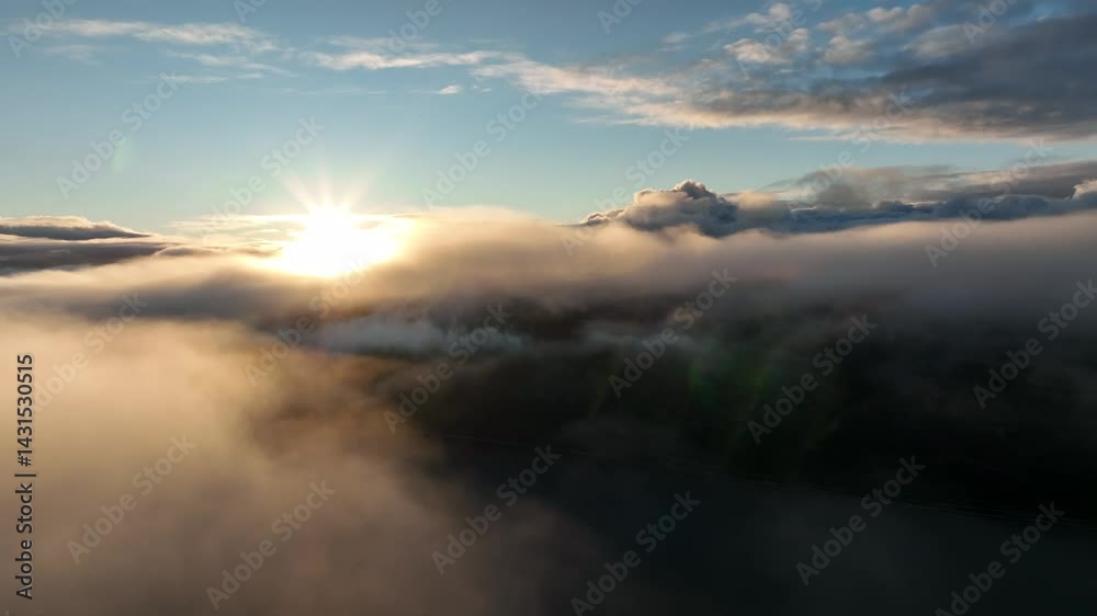 Aerial view from drone flying over the fog and low clouds above coastal landscape with blue water Aerial view from drone flying over the fog and low clouds above coastal landscape with blue water