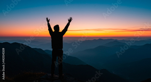 Wallpaper Mural Silhouette of a person with arms raised stands atop a mountain as the sun sets, casting warm colors across the horizon. Torontodigital.ca
