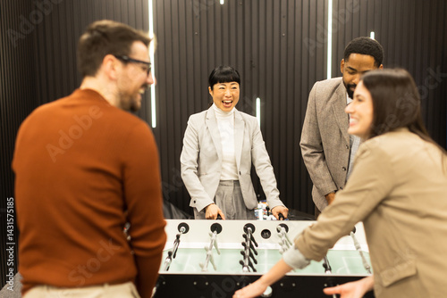 Engaging group enjoys a lively foosball game in a modern creative space