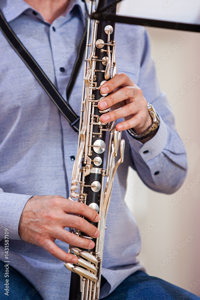 Fototapeta premium A fragment of a bass clarinet in the hands of a musician