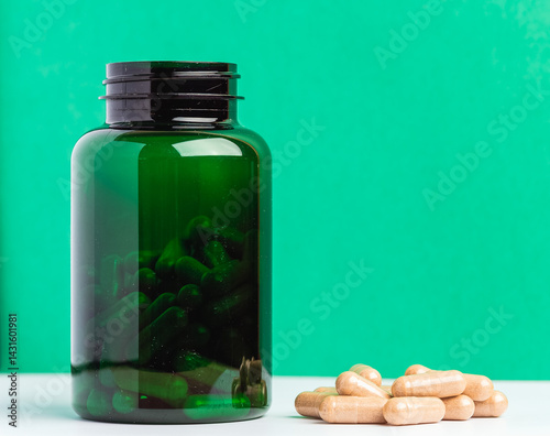 Green Supplement Bottle with Capsules Against a Vibrant Background