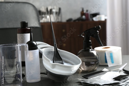 Fotografia Bleaching powder and hairdresser's tools on grey table in salon