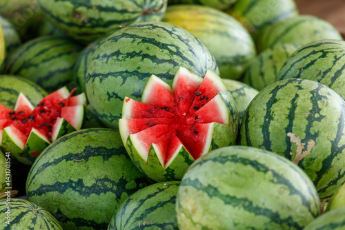 A bunch of watermelons with one cut in half